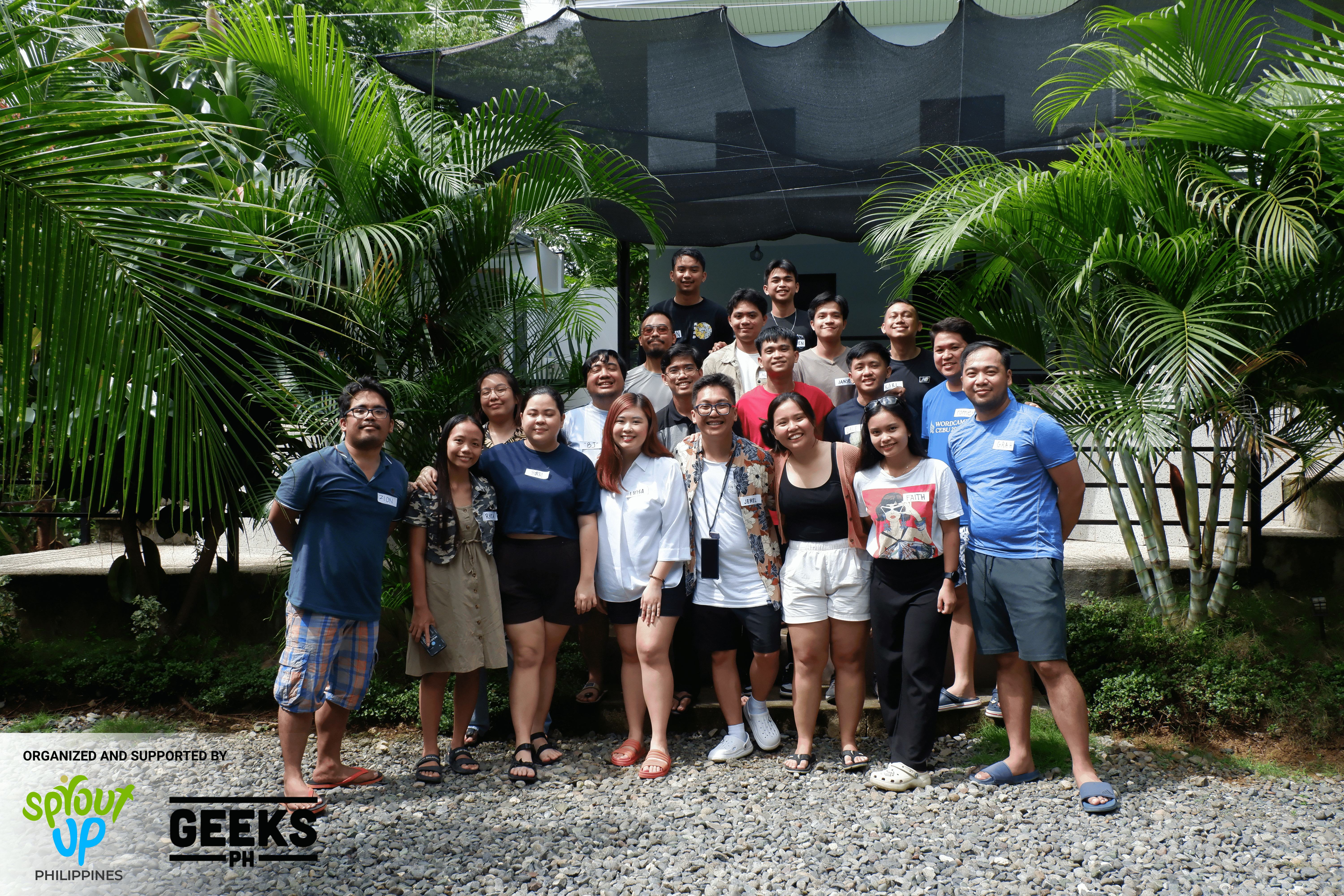 a group of people gathered and smiling at the camera in the tropical island of Bohol ready to start collaborating on the best way to develop community building models